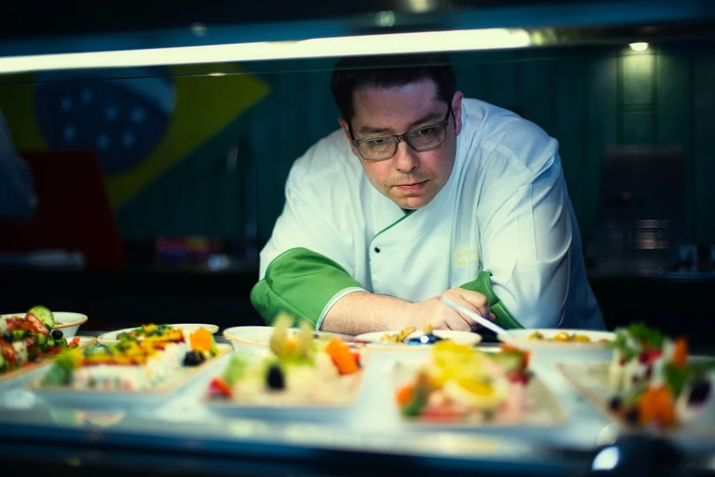 A restaurateur contemplates artfully presented dishes in the window, ready for service