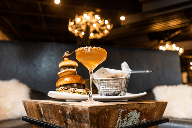 A restaurant table with food and wine sitting on a plank of wood and a perfect image for fall social media promotions