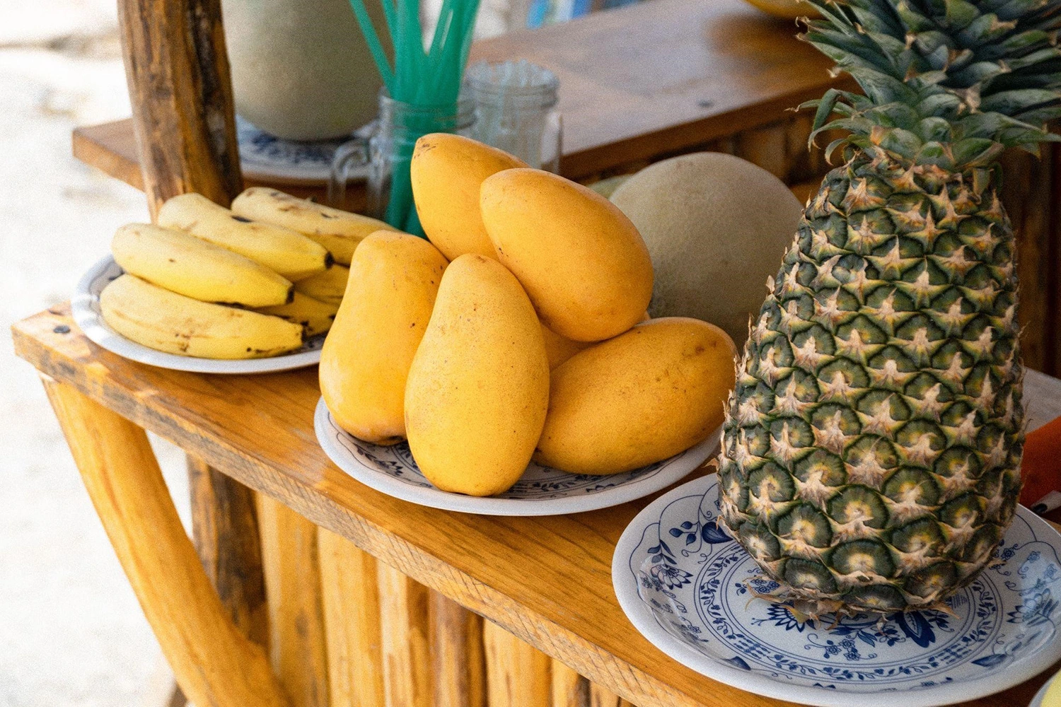 Culinary creativity on display with bananas, pineapples, and mangoes on a wooden table.