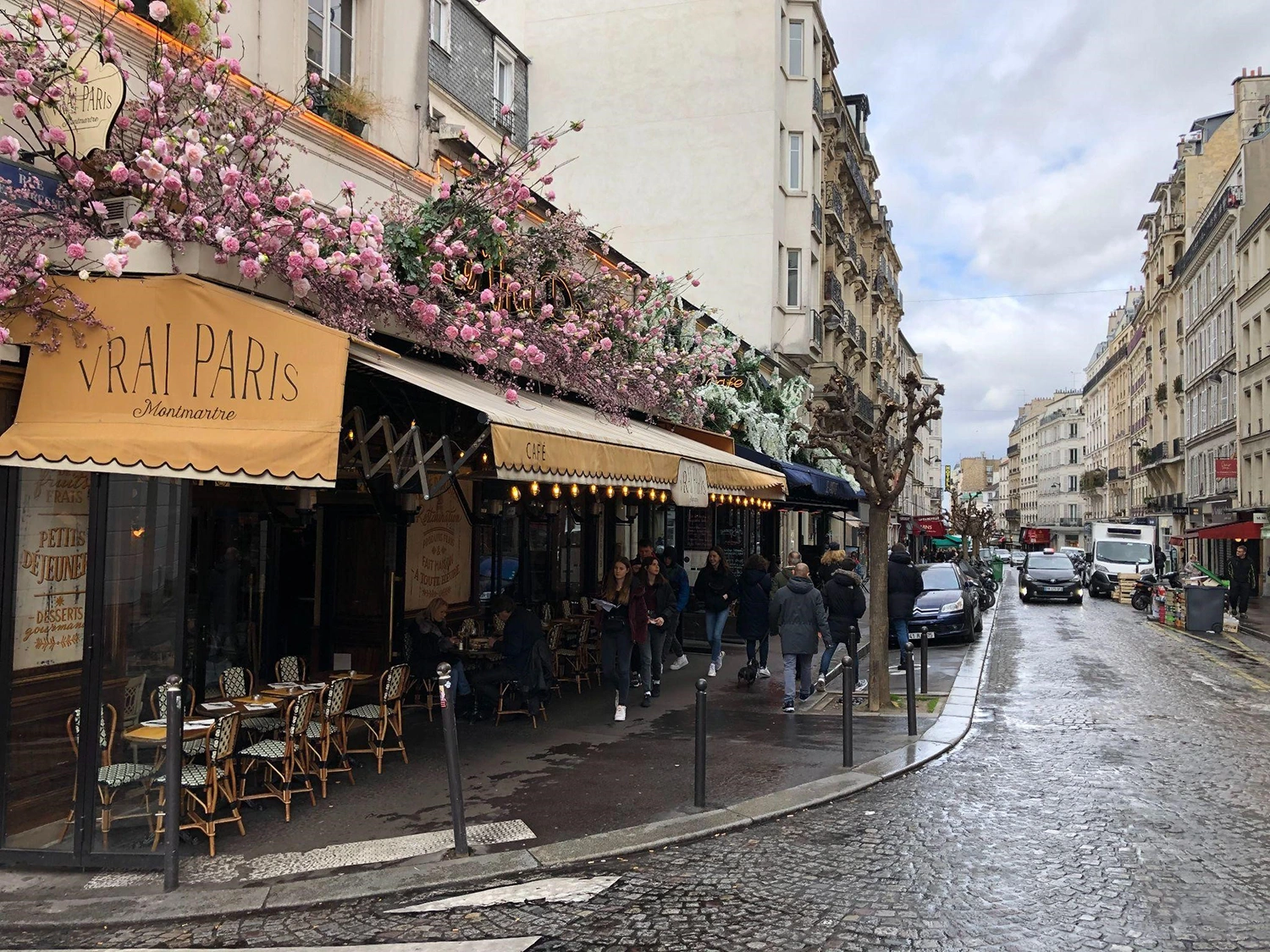 A wet street in Paris with a cafe on the corner; perhaps the chef created a seasonal menu that reflects the latest food trends.