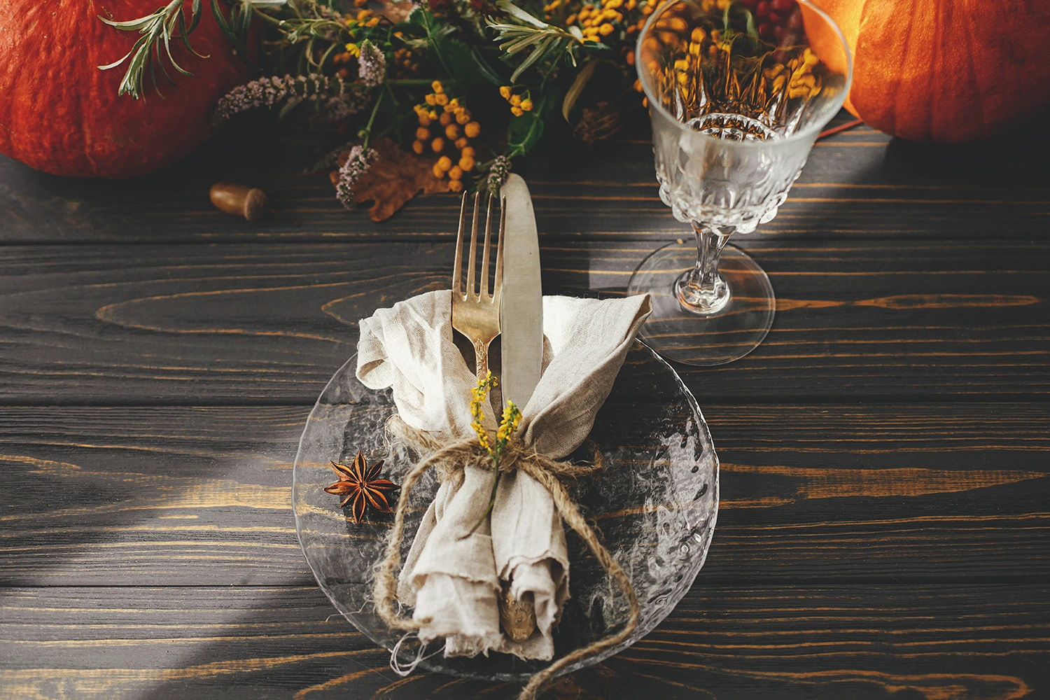 Thanksgiving table setting with a glass of wine and pumpkins for your restaurant's holiday menu.