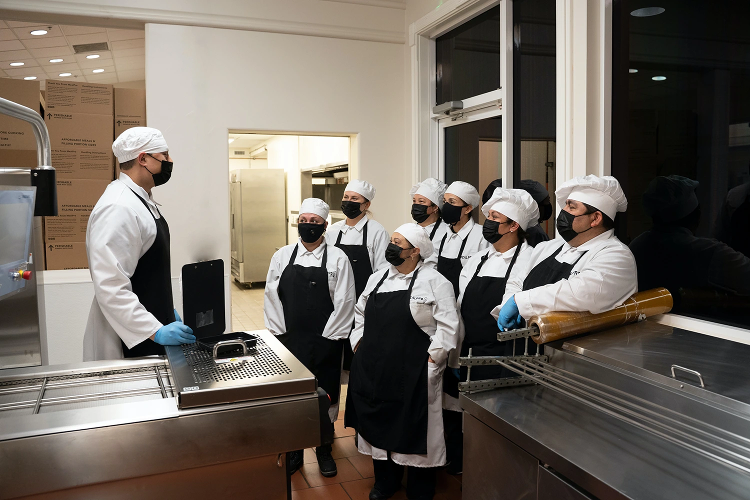 A group of chefs standing in a kitchen preparing the holiday menu for restaurants.